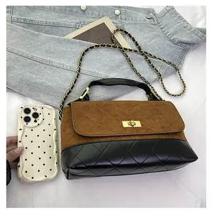 Close-up of contrast stitching, gold twist lock and metal chain on a quilted bucket bag
