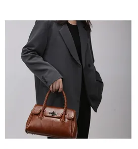 Détail du sac cabas marron avec poignées tressées et fermoir rotatif en métal argenté