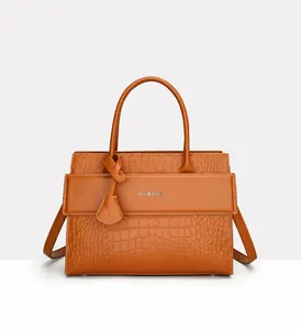 Detail showing brown crocodile-embossed leather texture and silver logo on tote bag