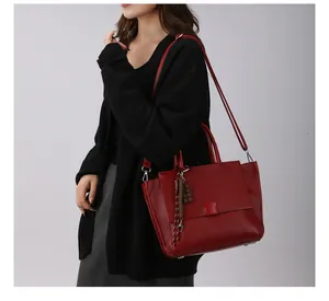 Detailweergave van een rode getextureerde leren shopper met kwastje en hanger detail