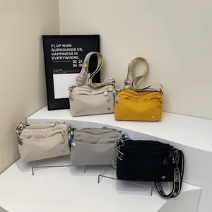 Detail of the jacquard wide strap and multi-pocket nylon shoulder bags in four colors