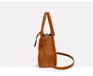 Detailed side view of brown faux crocodile leather handbag with silver metal hooks