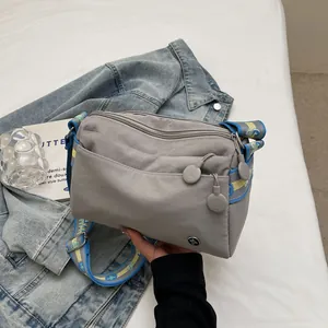 Detail of grey canvas tote with vibrant blue and yellow embroidered wide strap for daily use