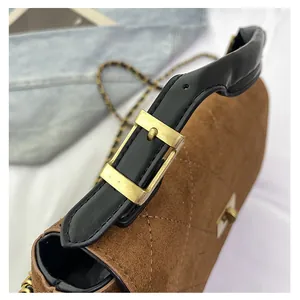 Detail shot of brown quilted suede bucket bag with matte gold hardware and leather strap
