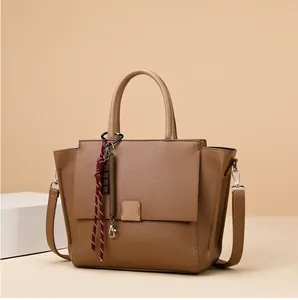 Detail van bruine shopper van generfd leer met schouderriem en mooie hanger