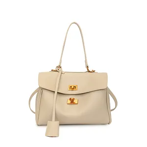 Close-up of cream leather tote bag featuring vintage dual metallic twist-lock fasteners