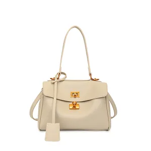 Detailed view of cream leather handbag featuring a golden swivel lock and detachable strap
