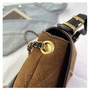 Detail view of brown suede bucket bag featuring quilted stitching and gold chain strap