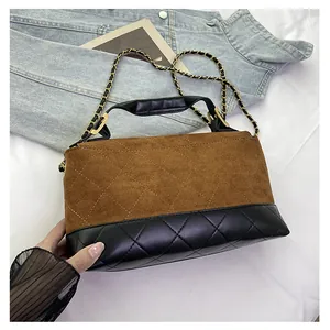 Detailed close-up of quilted contrast chain bag with matte brown and black leather texture