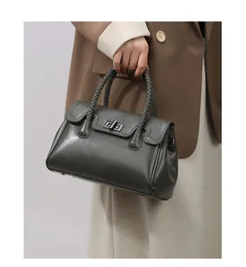 Détail de la poignée tressée et du fermoir vintage sur un sac fourre-tout en cuir