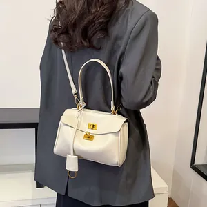 Retro cream white large capacity tote bag with dual gold locks worn by a model