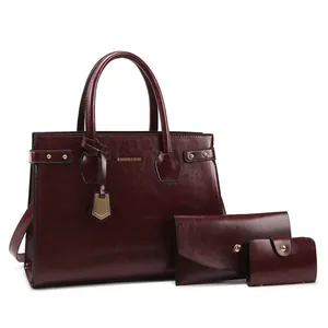 Deep red three-piece handbag set featuring a tote, clutch, and card holder with gold hardware