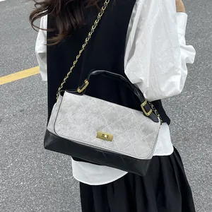 Quilted gray and black shoulder bag with gold clasp and chain strap on a model