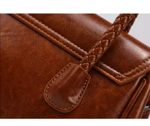 Gros plan de la poignée tressée et du cuir marron vintage avec coutures détaillées