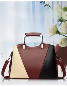 Detail of color-block tote bag featuring lychee grain leather and metal handles