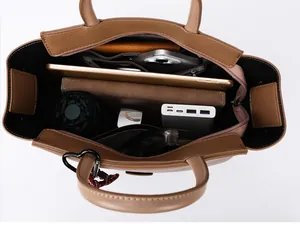 Bovenaanzicht van het ruime interieur van de bruine lederen shopper met gadgets en accessoires