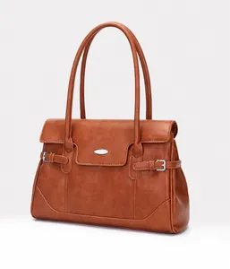 Detail der karamellbraunen Ledertasche mit feiner Narbung und Metallschnallen-Akzenten