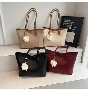 Detail view of large faux leather tote bags in four colors with cute sheep charms