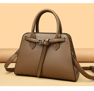 Dettaglio macro della borsa a mano in pelle martellata marrone con nodo decorativo