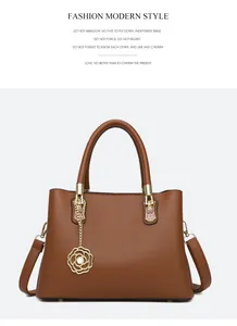Detailansicht aus braunem Leder mit Litschi-Muster und goldenem Rosenanhänger der Tasche