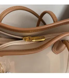 Detail of premium golden metal zipper puller on a beige stylish tote bag