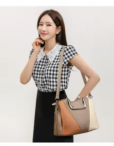 Detailed side view of a large color-block faux leather tote bag with metallic handles