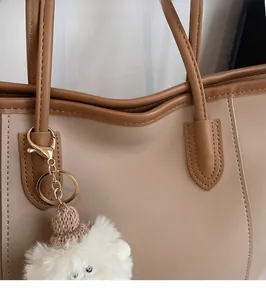 Detailed view of the fine stitching and metallic buckle on a brown tote handbag