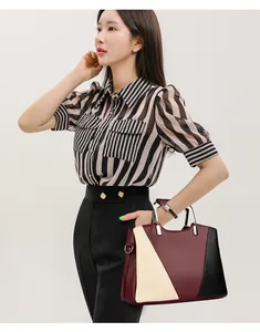 Modern tote bag with burgundy, cream, and black patchwork featuring a pebbled leather texture
