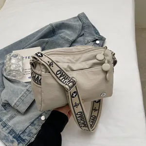 Detail of beige canvas crossbody bag with jacquard SJCHAO strap and multi-layer zippers