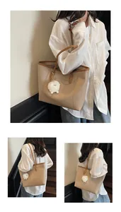 Detail view of large beige tote bag with brown trim and plush sheep charm decoration