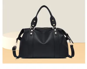 Detail of black pebbled leather Boston bag with gold rivets and dual zipper closure