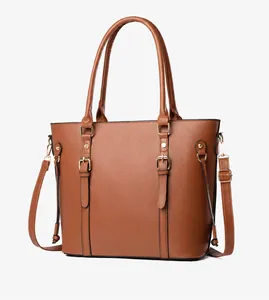 Detail of brown faux leather tote with cross-grain texture and gold metal buckles