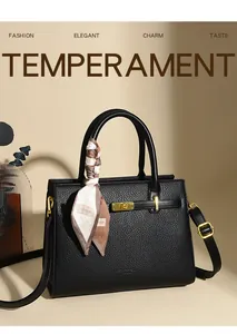 Detail of black pebbled leather handbag featuring gold twist lock and silk scarf