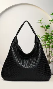 Close-up of black woven leather texture on a minimalist large capacity hobo shoulder bag