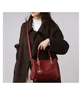 Detail der roten Handtasche aus Kieselleder mit Goldbeschlägen und Rosenanhänger