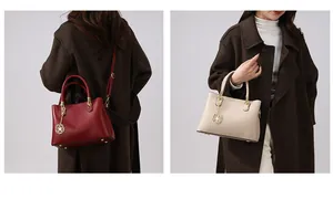 Detail einer minimalistischen Ledertasche mit Blumenanhänger und Metallfüßen in zwei Farben