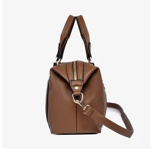Detail of brown litchi pattern leather handbag showing side view and golden hardware