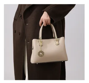 Detailansicht beige Handtasche mit Leder-Litschi-Struktur und Gold-Rosenanhänger