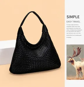Detailed view of black woven leather texture on a high-capacity minimalist hobo shoulder bag