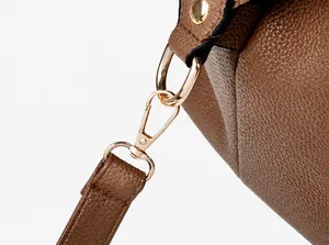 Macro shot of detachable shoulder strap with gold-tone metal hook and lychee grain leather