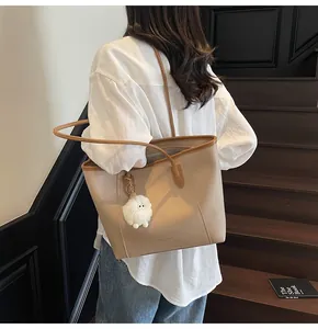 Beige tote bag with brown leather trim and a cute plush lamb charm on shoulder