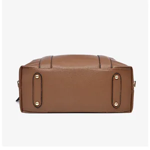 Detail of lychee textured leather bag bottom with golden metal protective rivets