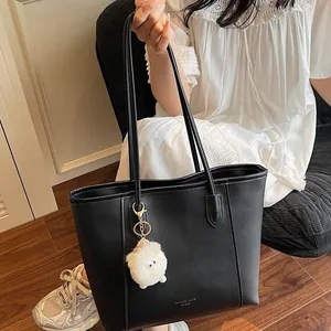 Black leather tote bag with Fashion Trend Paris text and cute plush monster charm