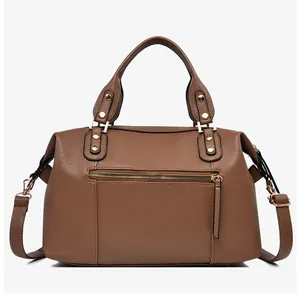 Close-up of brown litchi pattern leather Boston bag with gold rivets and zippers