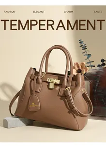 Détail du sac à main en cuir marron grainé avec cadenas doré et doubles poignées