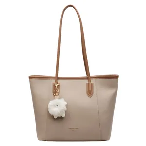 Khaki large capacity tote bag with dark brown straps and a cute plush lamb pendant