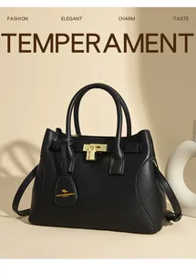 Détail d'un sac à main en cuir noir avec cadenas doré et doubles poignées rondes
