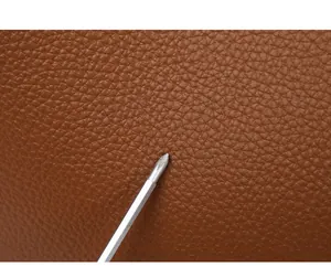 Makroaufnahme von kratzfestem braunem genarbtem Leder an einem Damenhandtaschen-Set
