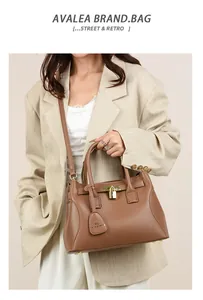 Détail d'un sac à main en cuir marron avec cadenas doré et étiquette motif kangourou