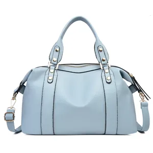 Detail view of light blue lychee pattern leather Boston bag with golden hardware